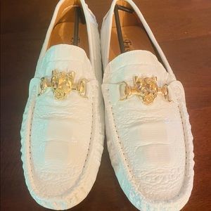 White mens loafers with gold embellishments.